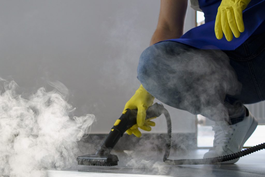 pessoa-de-servico-de-limpeza-profissional-usando-limpador-a-vapor-no-escritorio-1-1024x683